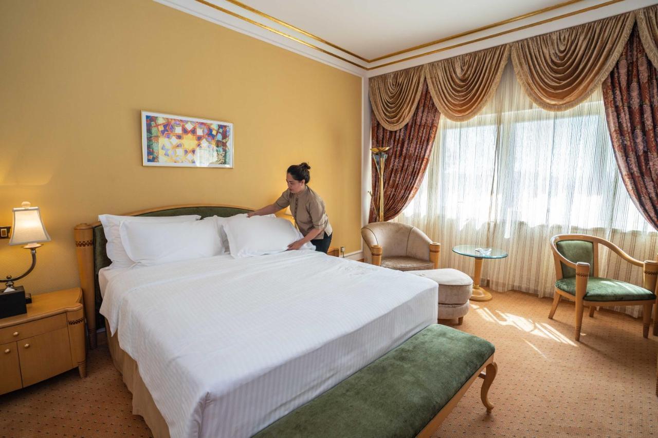 오피서 클럽 앤 호텔 아부다비 외부 사진 A chambermaid making a bed in a hotel room
